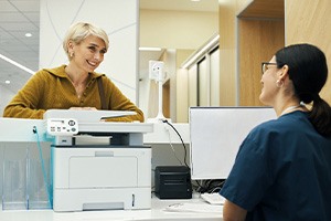 a dental patient speaking with a front desk staff member