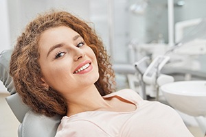 Female patient smiling after receiving dental implants in Dallas, TX