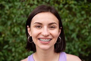 Woman with traditional braces in Dallas smiling