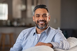 man smiling while sitting on a couch