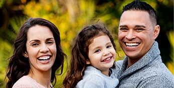 Man woman and child smiling outdoors