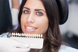 Woman's smile with tooth color chart