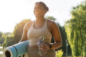 a smiling woman about to do yoga