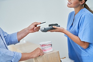 a person paying for a dental crown at a dental office