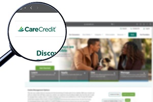 a magnifying glass zooming in on a CareCredit logo 