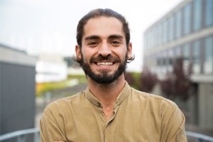 a smiling man standing outdoors