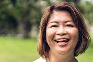 person smiling with a dental crown in Dallas, TX