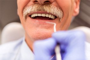 a dentist looking in a patient’s mouth