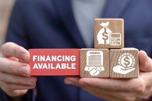 aa person holding building blocks with financing-related icons on them