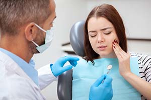 Woman with toothache visiting her Dallas emergency dentist