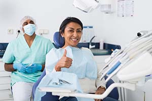 Woman gives thumbs up after toothache treatment