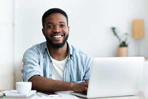 person smiling and working on their laptop