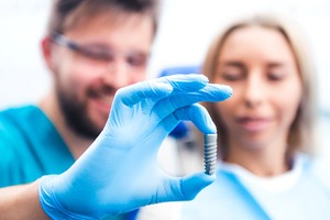 dentist showing dental implant in Dallas