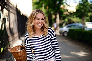 An older woman with dental implants in Dallas smiling outside