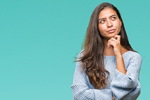 Woman thinking, looking up, and holding her chin