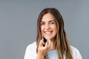 a woman putting Invisalign trays in her mouth