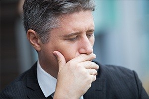 Man in suit covering his mouth