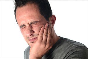 Man holding jaw in pain