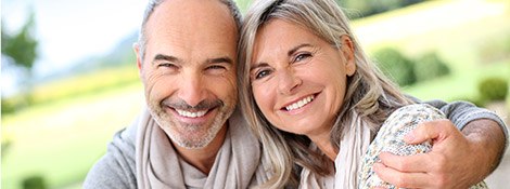 Smiling older man and woman sitting outdoors