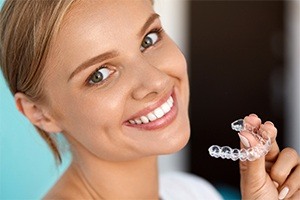 Woman holding Invisalign tray