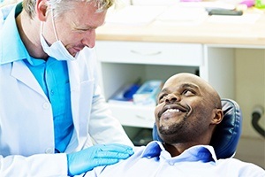 Man in dental chair smiling at dentist