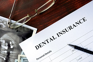 an empty dental insurance claim form with a pen on top of it