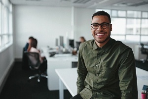 person sitting on a desk and smiling