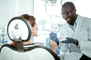 dentist showing a patient a model of a mouth