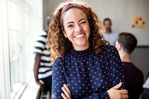 person smiling with their arms crossed