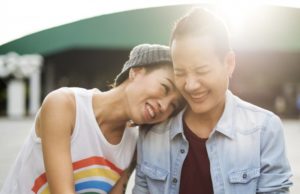 a happy couple resting their heads on each other and smiling