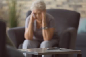 worried person sitting next to their cellphone