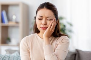 a person holding their face because they have a toothache