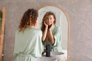 a woman looking at her smile in a mirror
