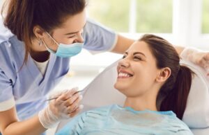 a dentist speaking with a patient while examining their mouth