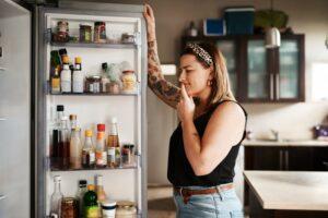a woman looking in a refrigerator
